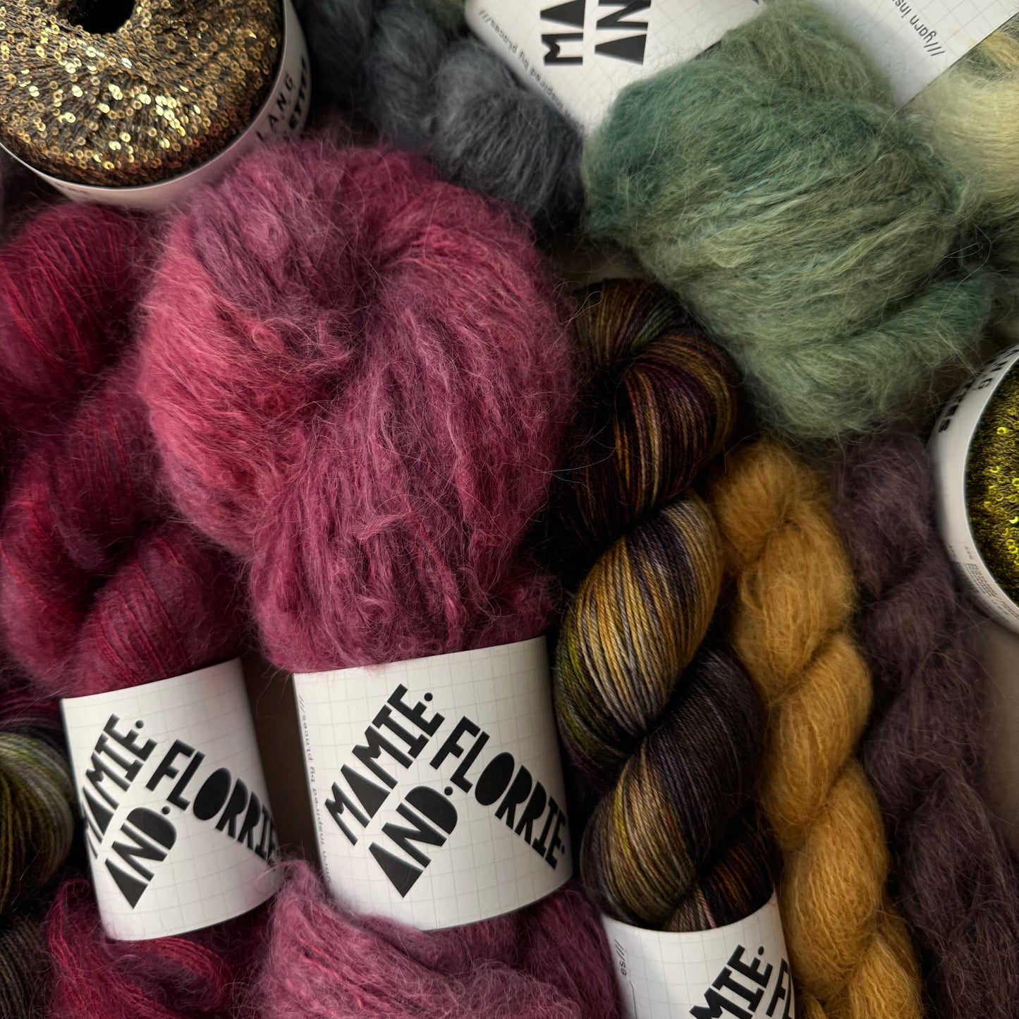 Colorful yarn skeins with labels on a textured surface